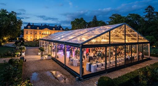 Chapiteau Cristal Panoramique illuminé au crépuscule dans un domaine d'Île-de-France